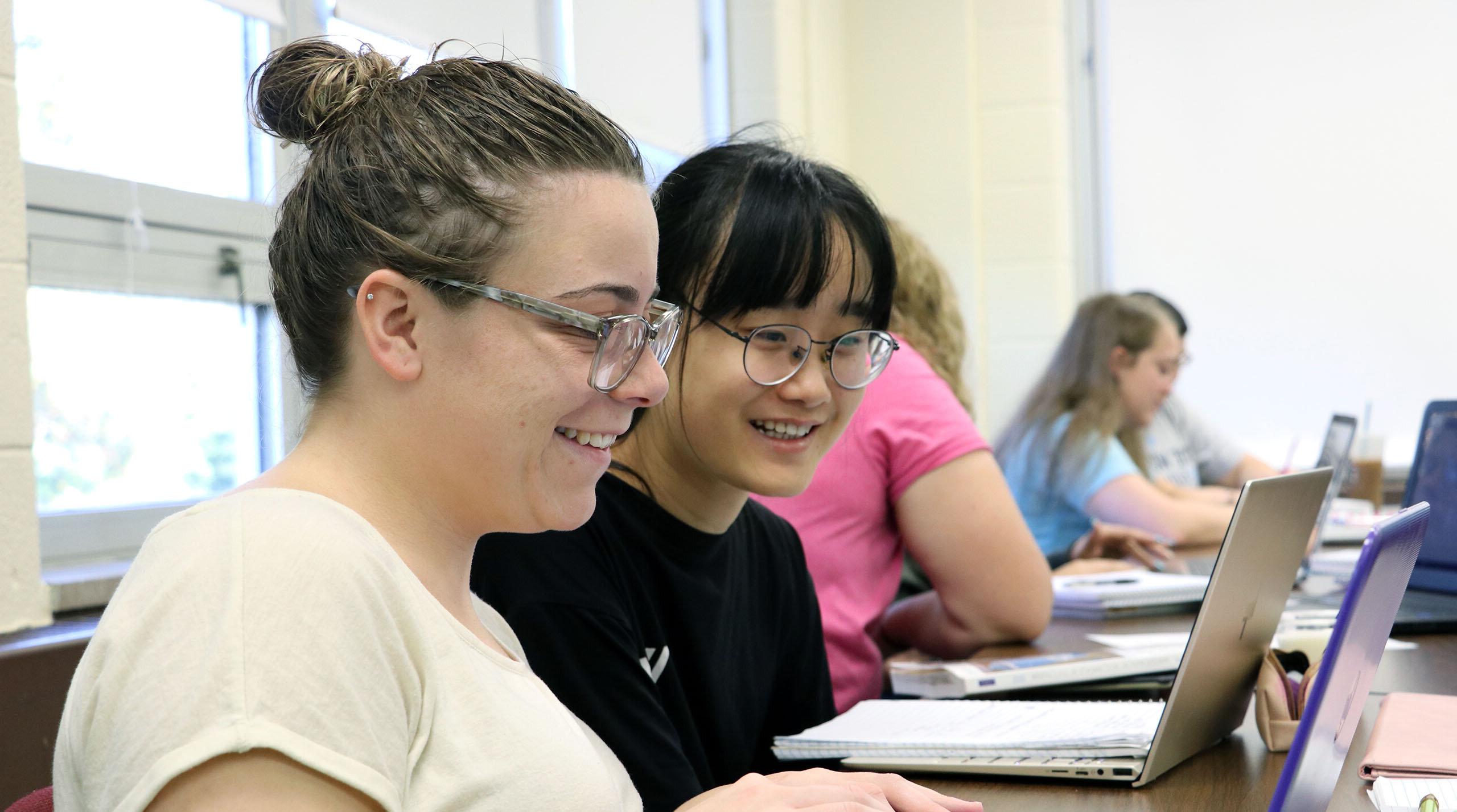 Students smiling and working in class